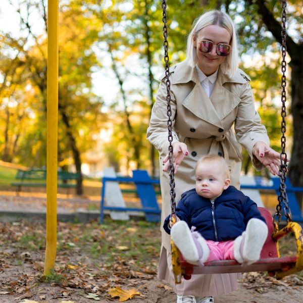 Mother playing with baby on swing